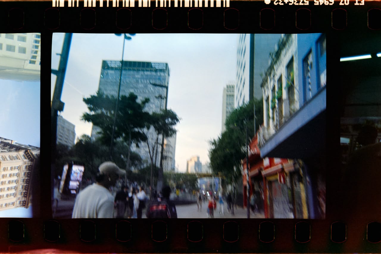 Rua embaçada ao entardecer, pessoas caminhando